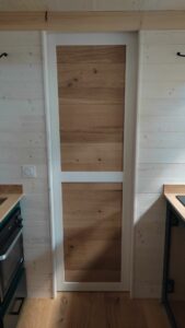 Fabrication d'une porte de salle de bain à galandage pour une tiny house à moutier au perche 61 par l'atelier bois robain